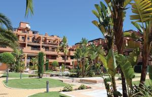 EsteponaGorgeous Apartment In Estepona With Sauna的一座棕榈树环绕的大建筑