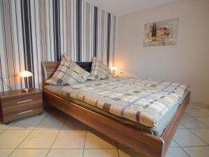 诺伊马根-德赫龙Holiday home with garden in Neumagen Dhron的一间卧室配有一张带2个床头柜和2盏灯的床。