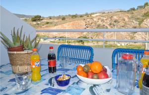 LújarAmazing Apartment In Ljar With Wifi的一张桌子,上面放着一碗水果和瓶装果汁