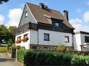 温特贝格Apartment in Langewiese near Winterberg的黑色屋顶的大型白色房屋