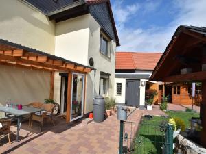 VeckenstedtApartment in the Harz Mountains with terrace的一个带桌椅的庭院和一座房子