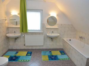 梅德巴赫Nice holiday home near ski area的浴室设有2个水槽、浴缸和2面镜子