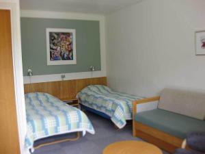 Fårup普尔胡斯克罗宾馆的一间小房间,配有两张床和一张沙发