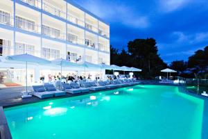 波蒂纳茨Grupotel Ibiza Beach Resort - Adults Only的酒店前的游泳池配有椅子和遮阳伞