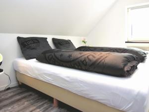 TrubenhausenModern holiday home in Hessen with private terrace的一张床上有黑色枕头的睡床