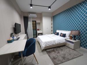 Ban Nong PhaiRoomQuest Rojana Industrial Estate area的酒店客房配有一张床、一张书桌和一张书桌。