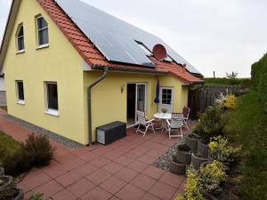 博伊恩斯多夫Peaceful Holiday Home in Boiensdorf with Terrace的屋顶上设有太阳能电池板的黄色房子