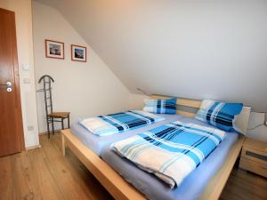 博伊恩斯多夫Peaceful Holiday Home in Boiensdorf with Terrace的一间卧室配有一张带蓝色和白色枕头的床