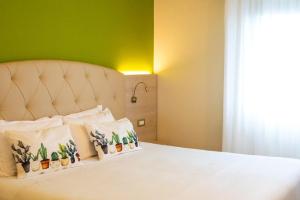 圣彼得罗-泰尔梅堡卡萨罗爱米迪克瑞斯酒店的一间卧室配有一张白色的床和绿色的墙壁