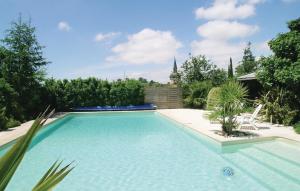 La Jonchère拉容谢勒2号度假屋的庭院里的大型游泳池,设有椅子和树木