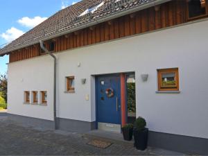 埃斯洛黑Apartment in Eslohe with terrace的白色的房子,设有蓝色的门和窗户