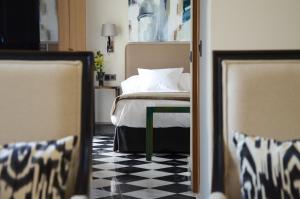 塞维利亚赛维拉阿圭拉斯5号套房酒店的卧室配有一张床,铺有黑白的格子地板。
