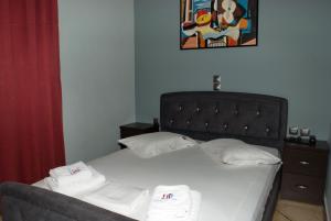 雅典迪尔特尼斯酒店的一间卧室配有一张床,上面有两条毛巾