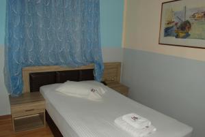 雅典迪尔特尼斯酒店的一间小卧室,配有带毛巾的床