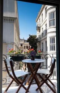 伊斯坦布尔佩拉尼乌酒店的一张桌子和椅子,坐在带窗户的阳台