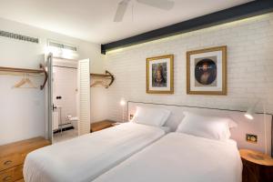 伊斯坦布尔佩拉尼乌酒店的卧室配有2张白色的床和砖墙