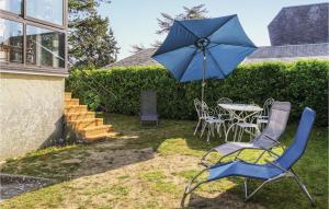 Hauteville-sur-MerNice Home In Hauteville-sur-mer With Wifi的蓝色雨伞、桌椅和一张带雨伞的桌子