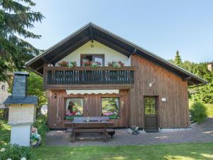 伦韦格地区诺伊豪斯holiday home with sauna Thuringian Forest的带阳台和长凳的房子