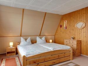 巴特利本施泰因Holiday cottage with terrace near the Rennsteig的一间卧室配有一张带2个床头柜和2盏灯的床。