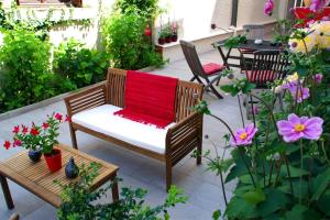 拉沙里泰Hôtel Mille et une Feuilles的庭院设有长凳和红色毯子