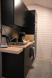 LumijokiWilla Rauha G的厨房配有黑色橱柜和水槽