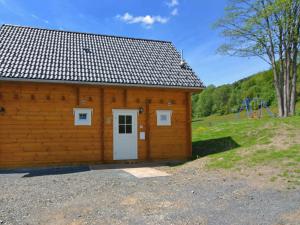 梅德巴赫Home in Wissinghausen with Private Sauna的一座带白色门和游乐场的木制建筑