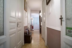 卡塔尼亚圣德梅特里奥酒店的走廊设有白色门,铺有瓷砖地板