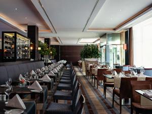德累斯顿普尔曼·德瑞斯登·纽沃酒店的餐厅内带桌椅的用餐室