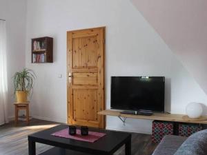 塔巴尔茨Apartment in Tabarz Thuringia near the forest的客厅配有平面电视和桌子。