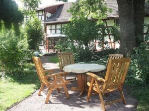 塔巴尔茨Apartment in Tabarz Thuringia near the forest的一张木桌、两把椅子和一张桌子