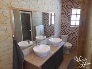 哈博罗内Moritshane estate的一间带三个水槽和镜子的浴室