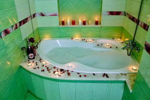 索契Sunlion Баунти Hotel的浴室配有带蜡烛的浴缸。