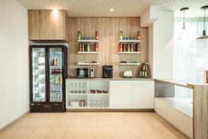 慕尼黑Wyndham Garden Munich Messe的厨房配有白色橱柜和冰箱。
