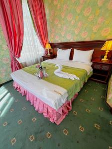 索契Sunlion Баунти Hotel的一间卧室配有一张带天鹅的床