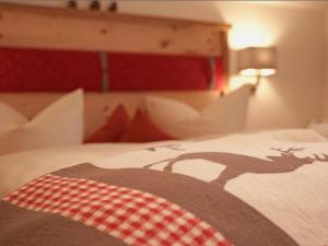 普夫龙滕Pension Alpenblick的一张带毯子的床,上面有鹿的照片