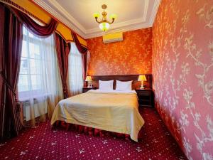索契Sunlion Баунти Hotel的一间设有床铺的卧室,位于一个拥有橙色墙壁的房间
