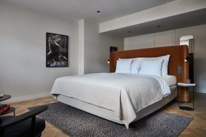 赫尔辛基赫尔辛基托尔尼索罗索酷酒店的一间卧室配有一张带白色床单的大床