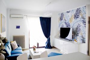哈尔基斯Ermis Mini Suite # 3的客厅配有蓝色的沙发和电视