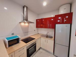 内尔哈卡皮斯托诺玫瑰公寓酒店的厨房配有红色橱柜和白色冰箱