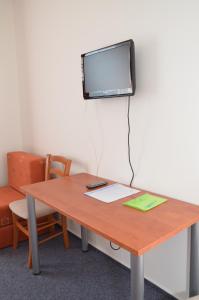 胡斯托佩切鲁泽尼酒店的一张桌子,墙上配有电视和书桌