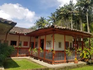 萨兰托Hostal Rio Arabia - Valle De Cocora HOTEL的花园内带门廊的房屋