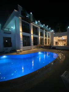 凯麦尔MİYAS LUXURY HOTEL的一座大楼前的大型游泳池