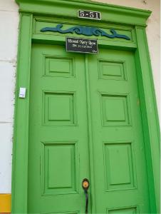贾丁Hostal Naty Luna的绿门,上面有标志