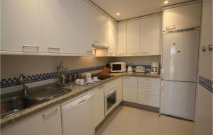 米哈斯科斯塔马贝拉罗萨里奥公寓的厨房配有白色橱柜、水槽和冰箱。