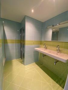 诺德韦克Fijn guesthouse的浴室设有两个水槽,铺有绿色和白色瓷砖。