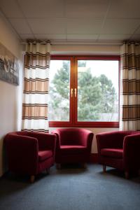 卡尔斯特RadlStadl - Brauhaus und Hotel的一间设有两张红色椅子和窗户的等候室