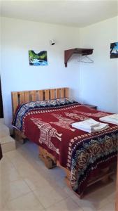 巴尼奥斯La Estancia de Runtún Km 7的一间卧室配有一张床铺,床上铺有红色毯子