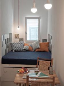 滨海波利尼亚诺小巢度假屋的小房间设有一张带桌子和桌子的床铺