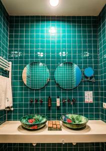 Art'anaChateau Artwine的绿色瓷砖浴室设有两个水槽和镜子
