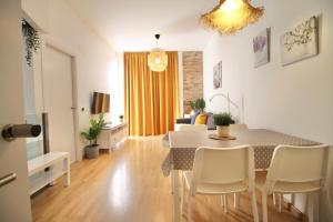 塔拉戈纳Mediterranean Way - Tarragona Central Apartments的用餐室以及带桌椅的起居室。